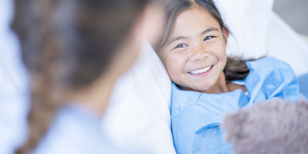 Child smiling hospital bed